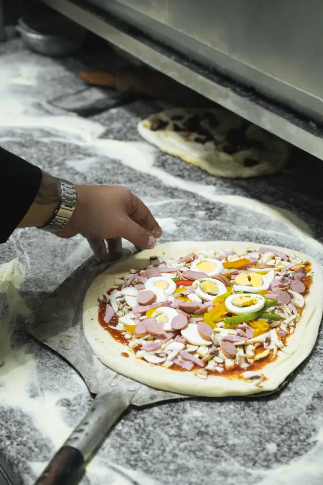 Chef preparing a pizza in the kitchen